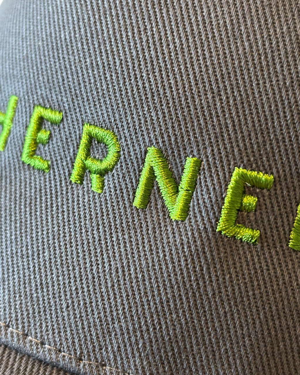 Close up of the front stitching detail on a dark dad cap with Northerner embroidery / embroidered slogan logo. Hat for men and women - unisex. Great gift for someone from Yorkshire or Lancashire.