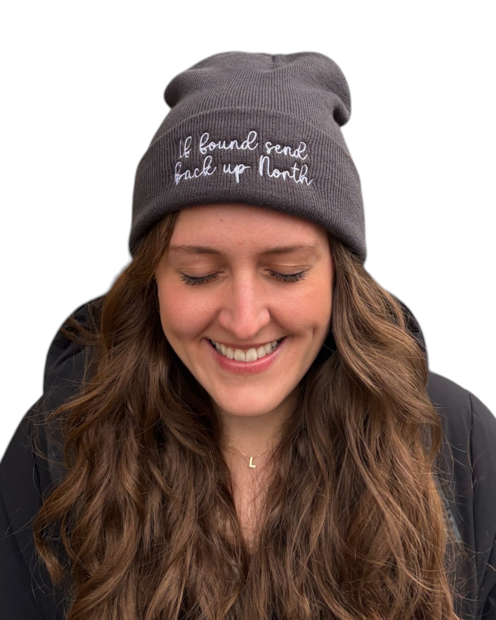 If found send back up North Northerner Yorkshire Lancashire funny Yorkshire Northern humour dialect gift - beanie hat to stay warm in cold weather and Winter. White embroidered handwriting font logo with star to the front cuff of the beanie. Dark grey charcoal hat. Female model with long wavy mousy  hair looking at the camera. Christmas gift. British humour gift. Unisex hat for women ladies and men.