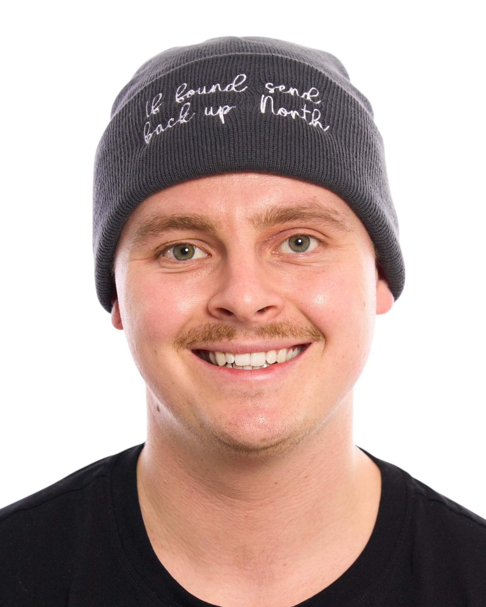 If found send back up North Northerner Yorkshire Lancashire funny Yorkshire Northern humour dialect gift - beanie hat to stay warm in cold weather and Winter. White embroidered handwriting font logo with star to the front cuff of the beanie. Dark grey charcoal hat. Female model with long wavy mousy  hair looking at the camera. Christmas gift. British humour gift. Unisex hat for women ladies and men.