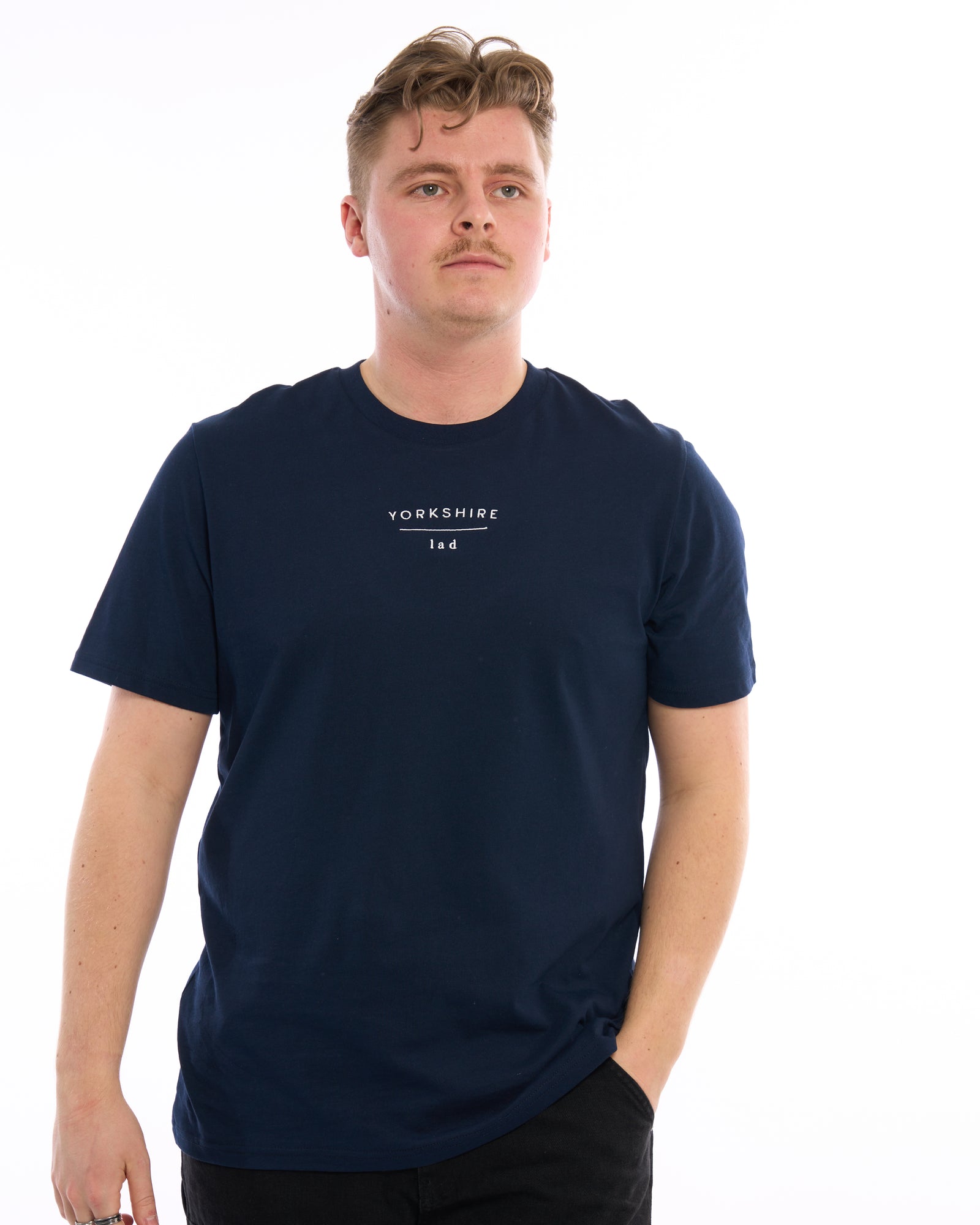 Male model wearing a Yorkshire lad dark navy blue t-shirt, with white embroidered slogan / logo. 100% organic cotton premium heavy thick quality t-shirt top. Minimalist design. Northern clothing. 