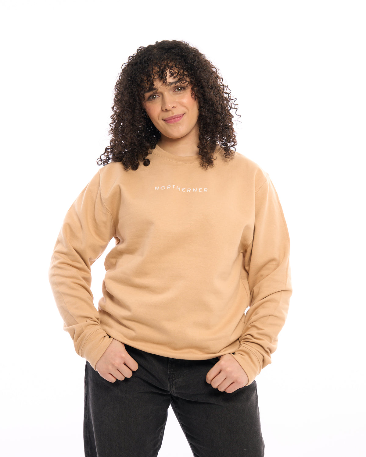 LighthouseLane unisex beige sweatshirt with Northerner embroidery worn by a woman with curly hair on white background