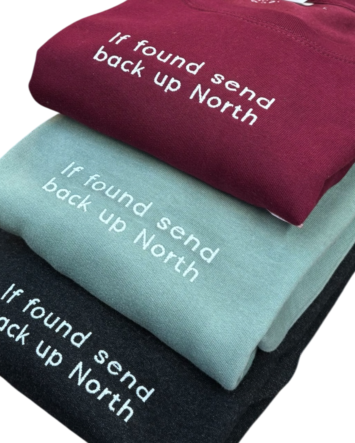 LighthouseLane unisex sweatshirts in burgundy, sage green, and black with If Found Send Back Up North embroidery.