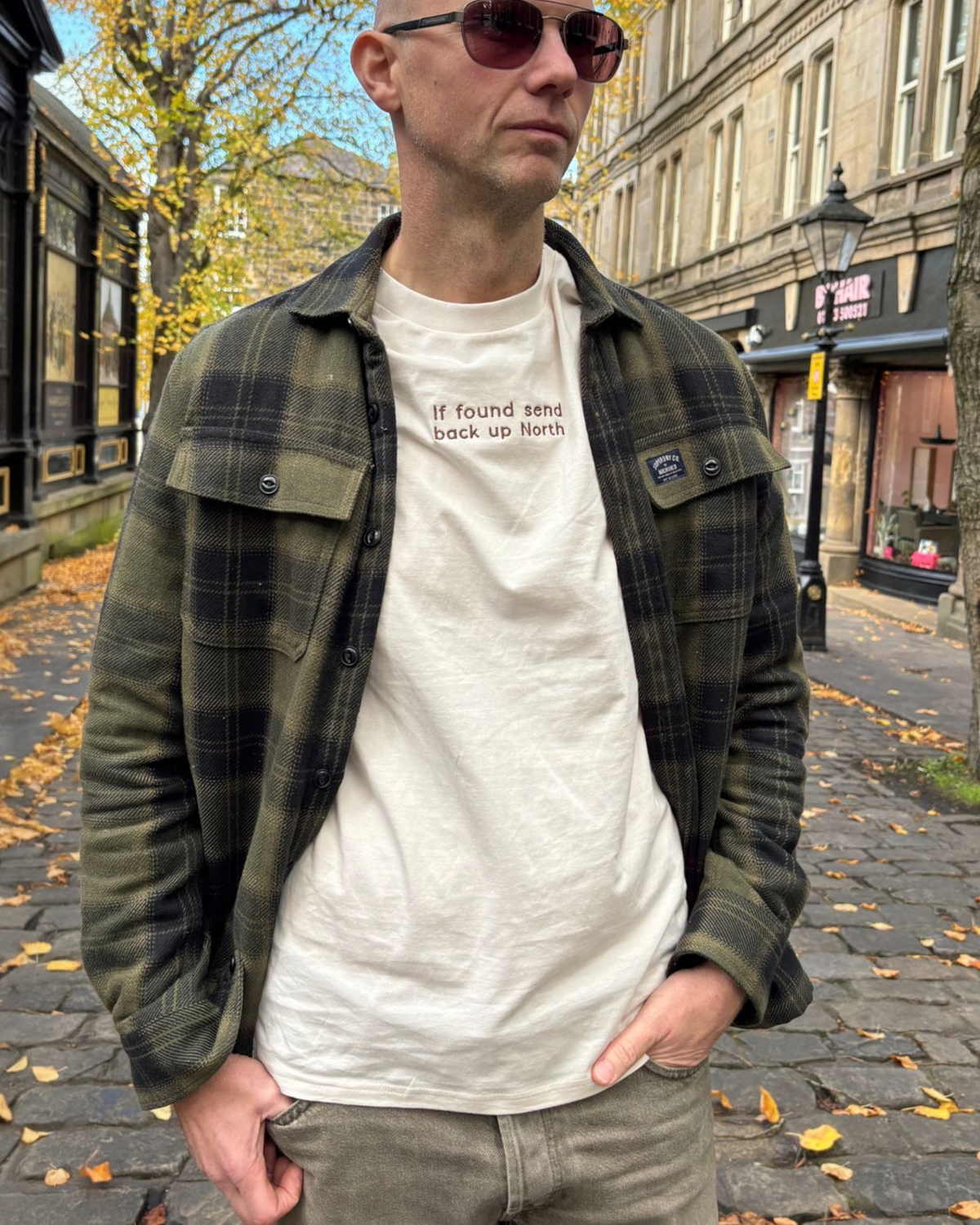 LighthouseLane organic cotton t-shirt with If Found Send Up North embroidery worn by a man in a plaid overshirt