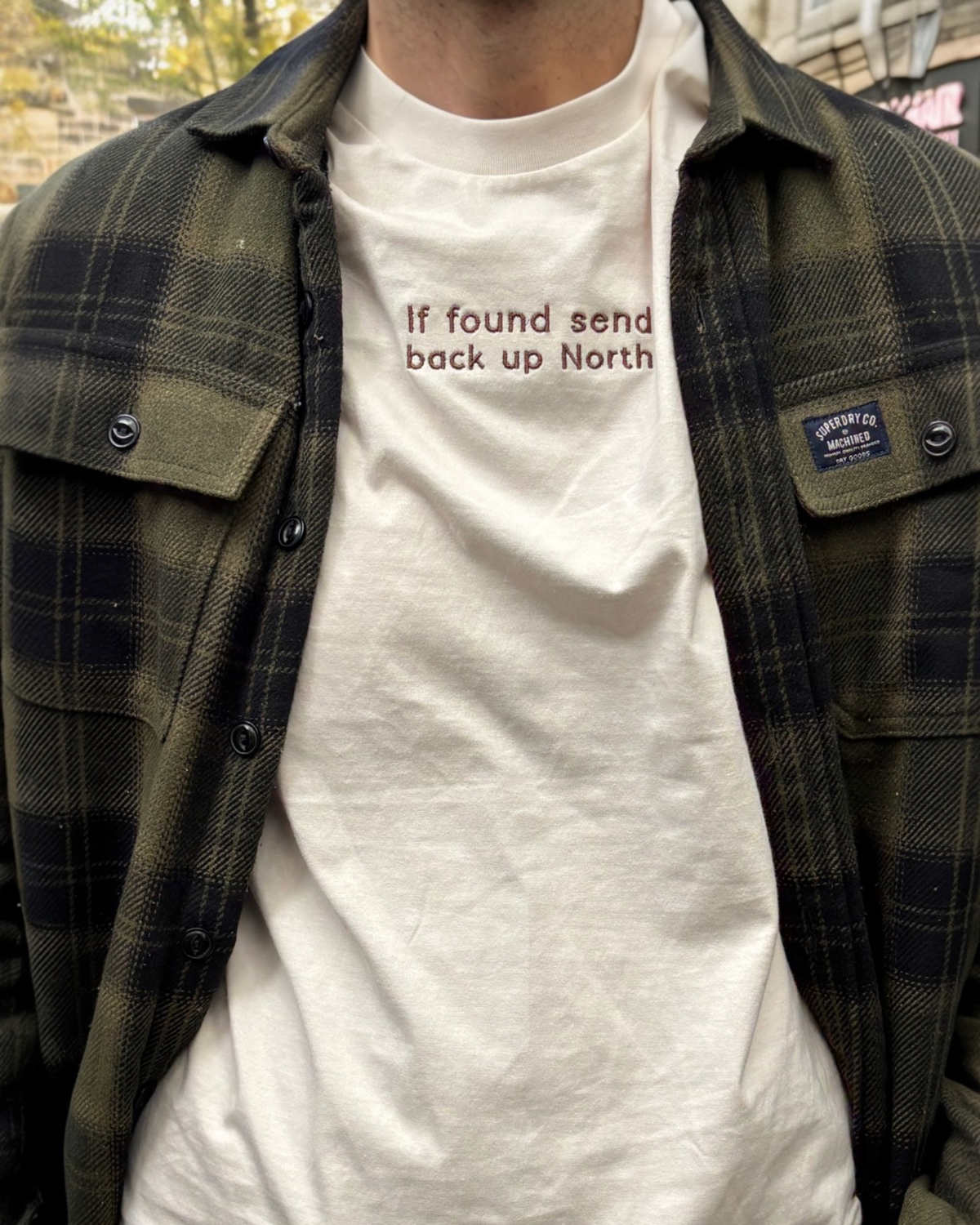 LighthouseLane white organic cotton t-shirt with If Found Send Up North slogan embroidery worn under a plaid shirt