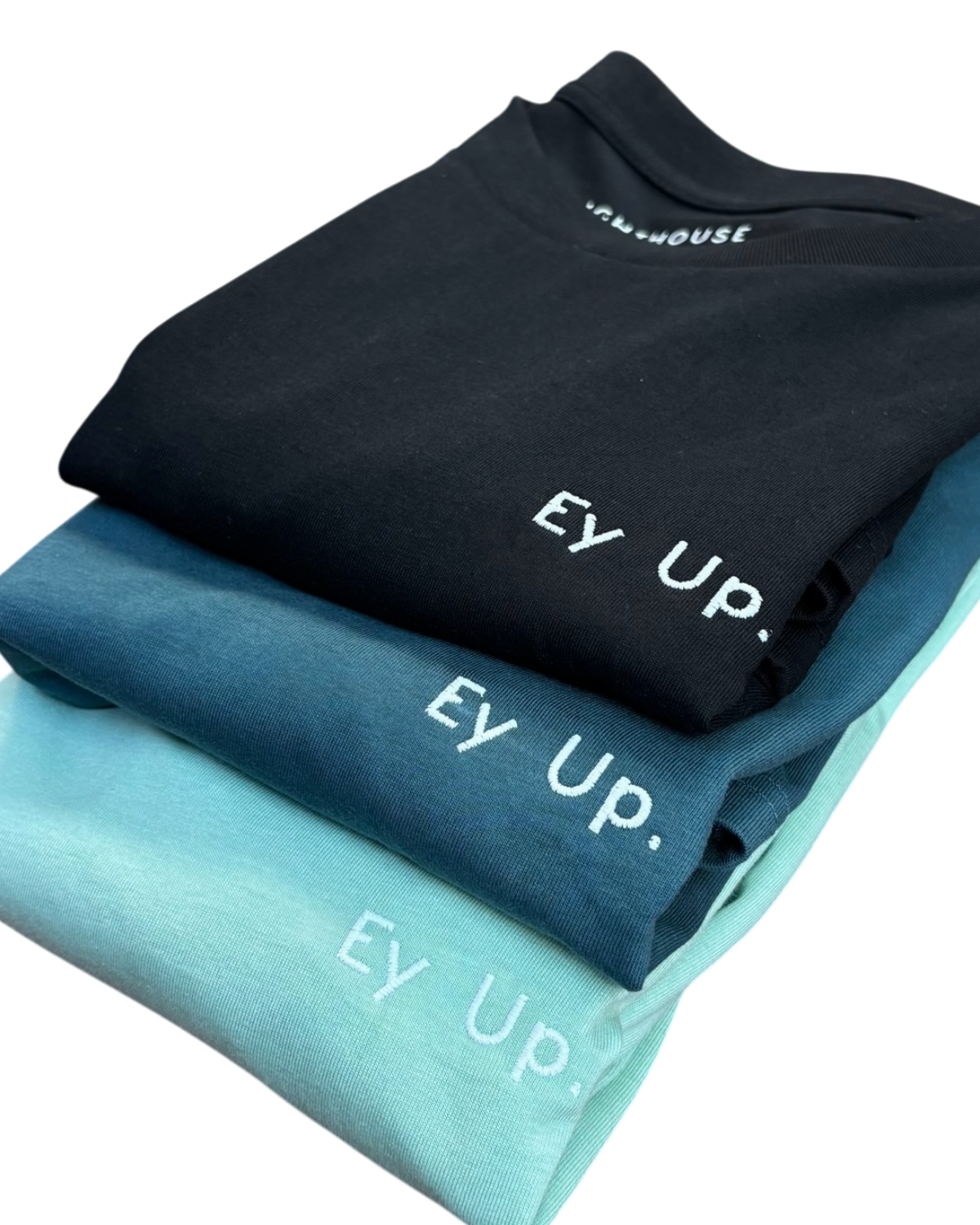 LighthouseLane organic cotton t-shirts in black, navy, and mint green with embroidered Ey Up slogan
