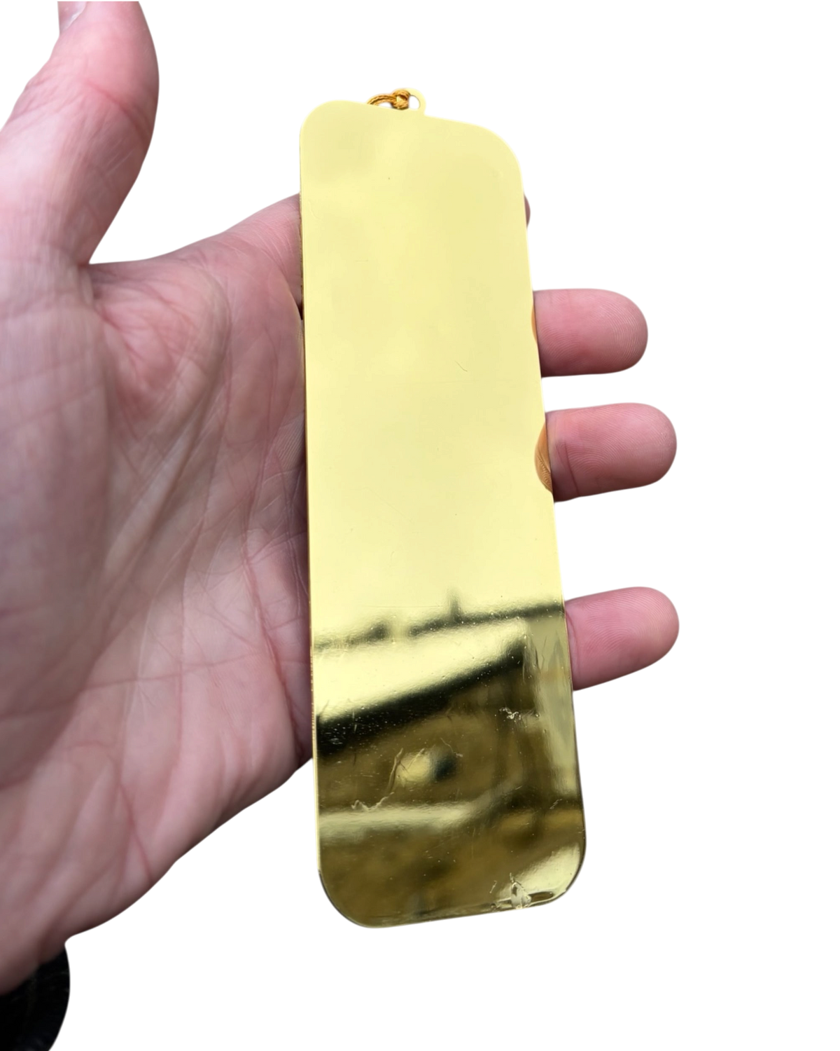 LighthouseLane Wuthering Heights bookmark with a reflective gold finish and a matching gold tassel held in a hand