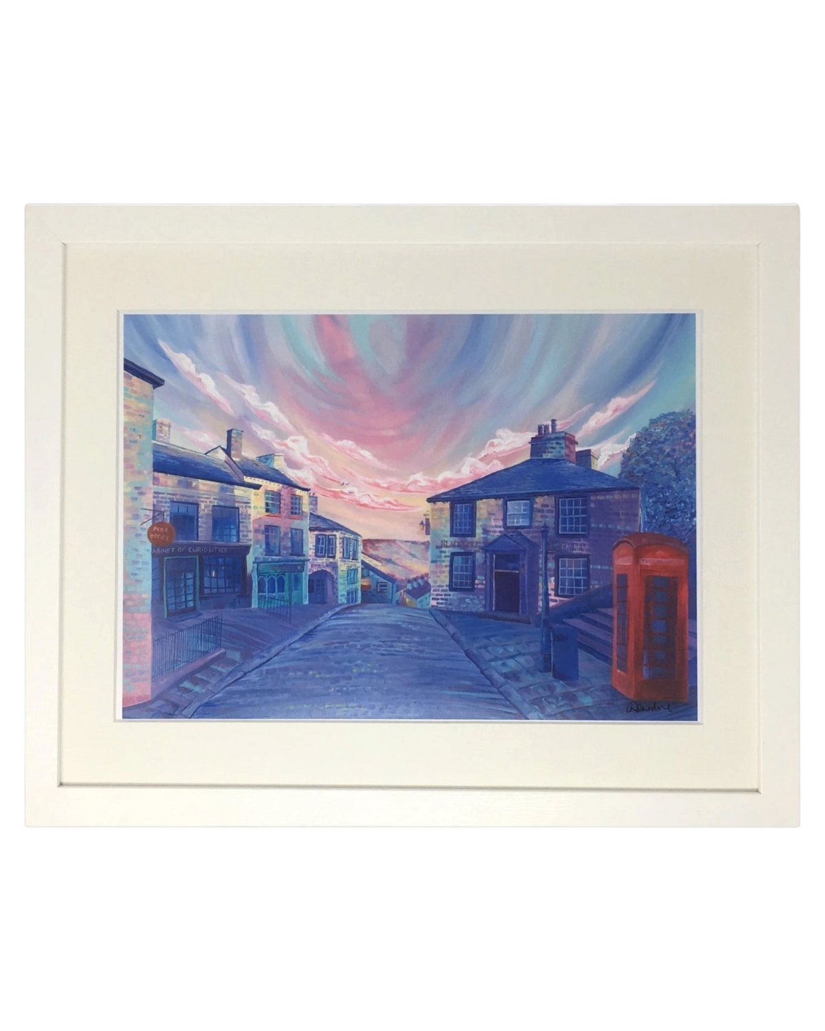 LighthouseLane framed print of Haworth Brow Main Street featuring a vibrant sunset sky and red telephone box.