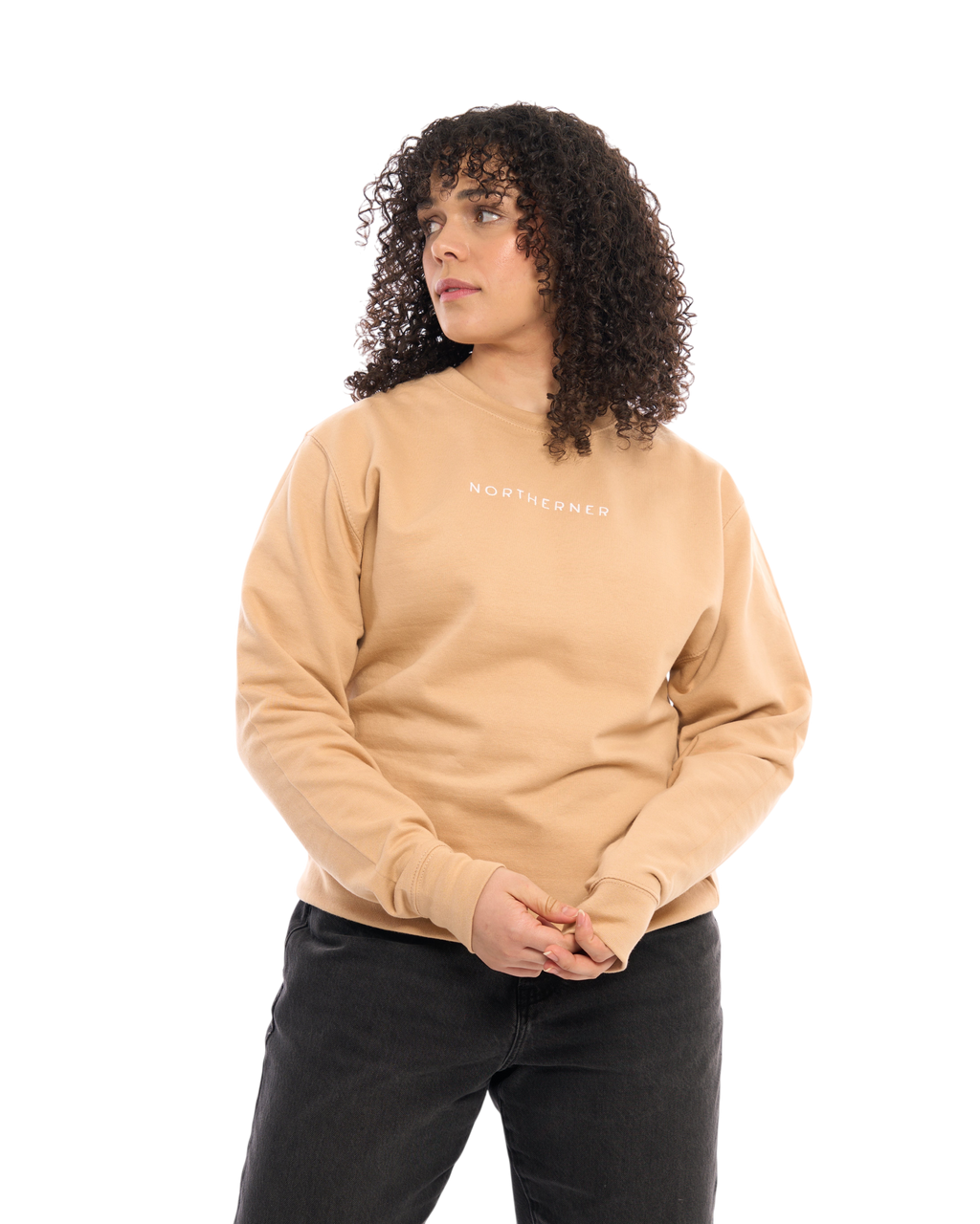 LighthouseLane Northerner embroidered beige unisex sweatshirt worn by a woman with curly hair on a white background