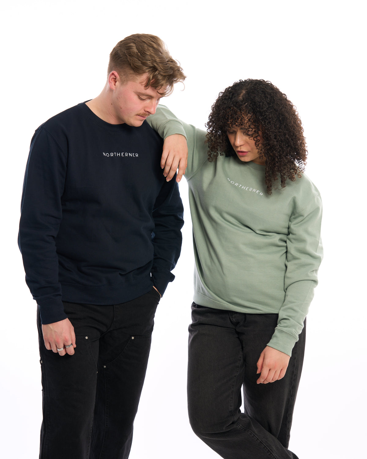LighthouseLane unisex Northerner embroidered sweatshirts in navy and sage green worn by a man and a woman.
