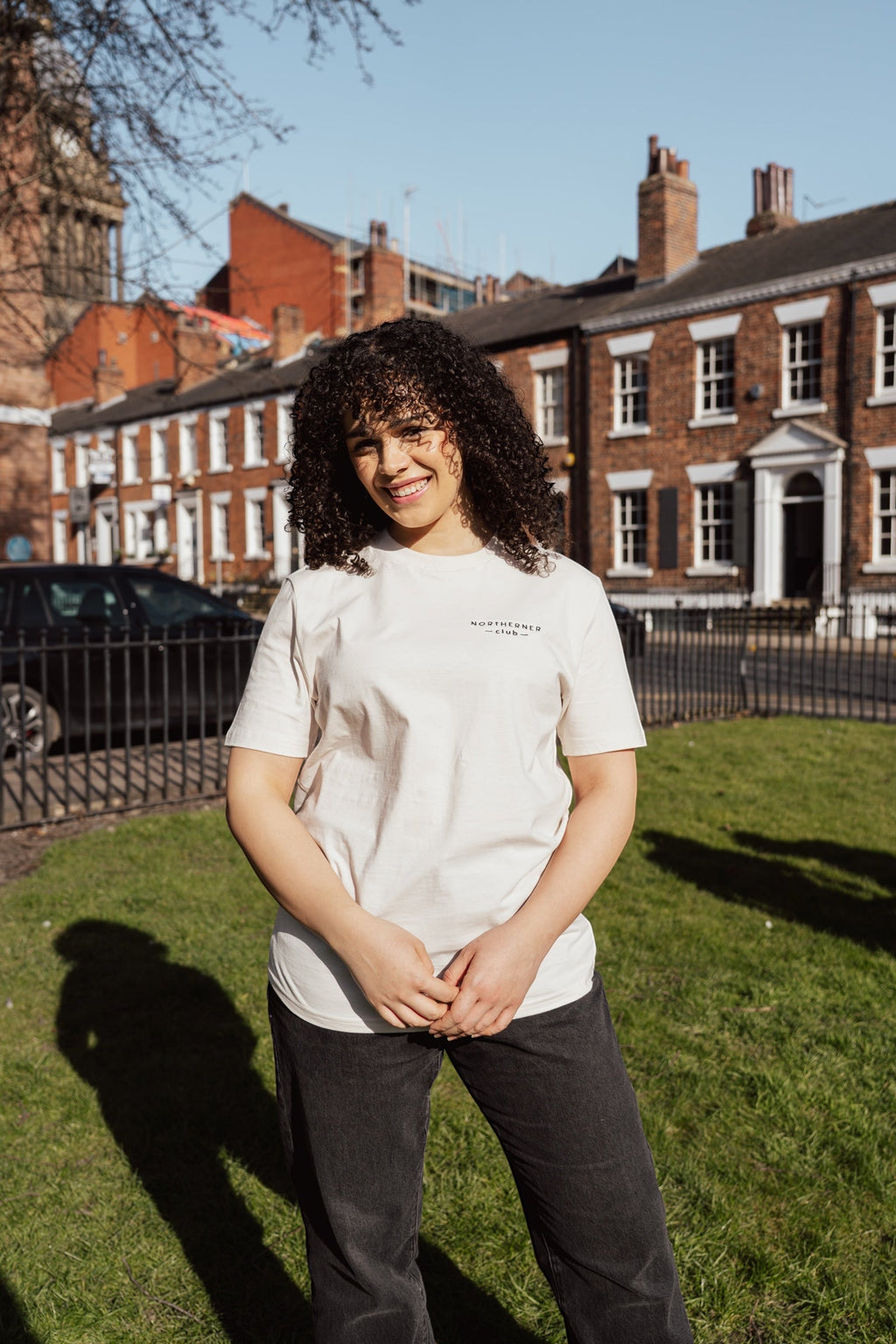 LighthouseLane unisex organic cotton t-shirt with Northerner Club embroidery worn by a woman in a sunny town square