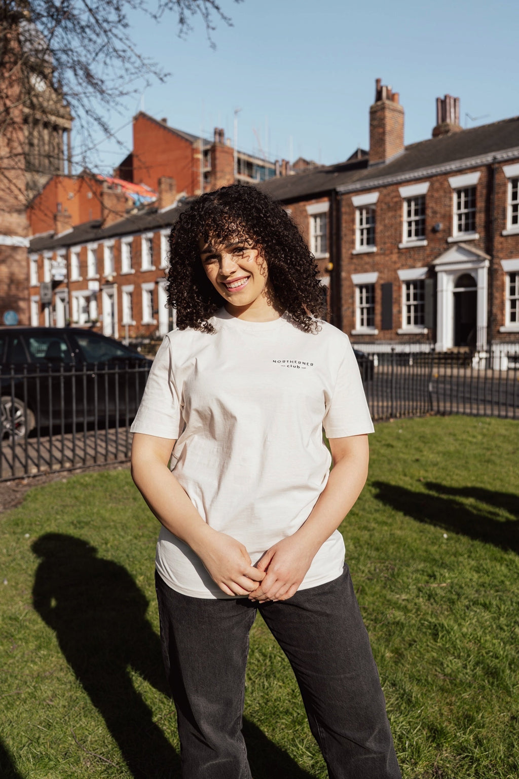 LighthouseLane unisex organic cotton t-shirt with Northerner Club embroidery worn by a woman in a sunny town square