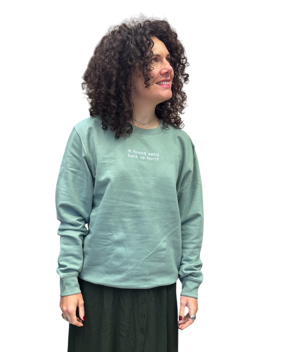 LighthouseLane sage green unisex sweatshirt with If Found Send Back Up North embroidery worn by a woman with curls.