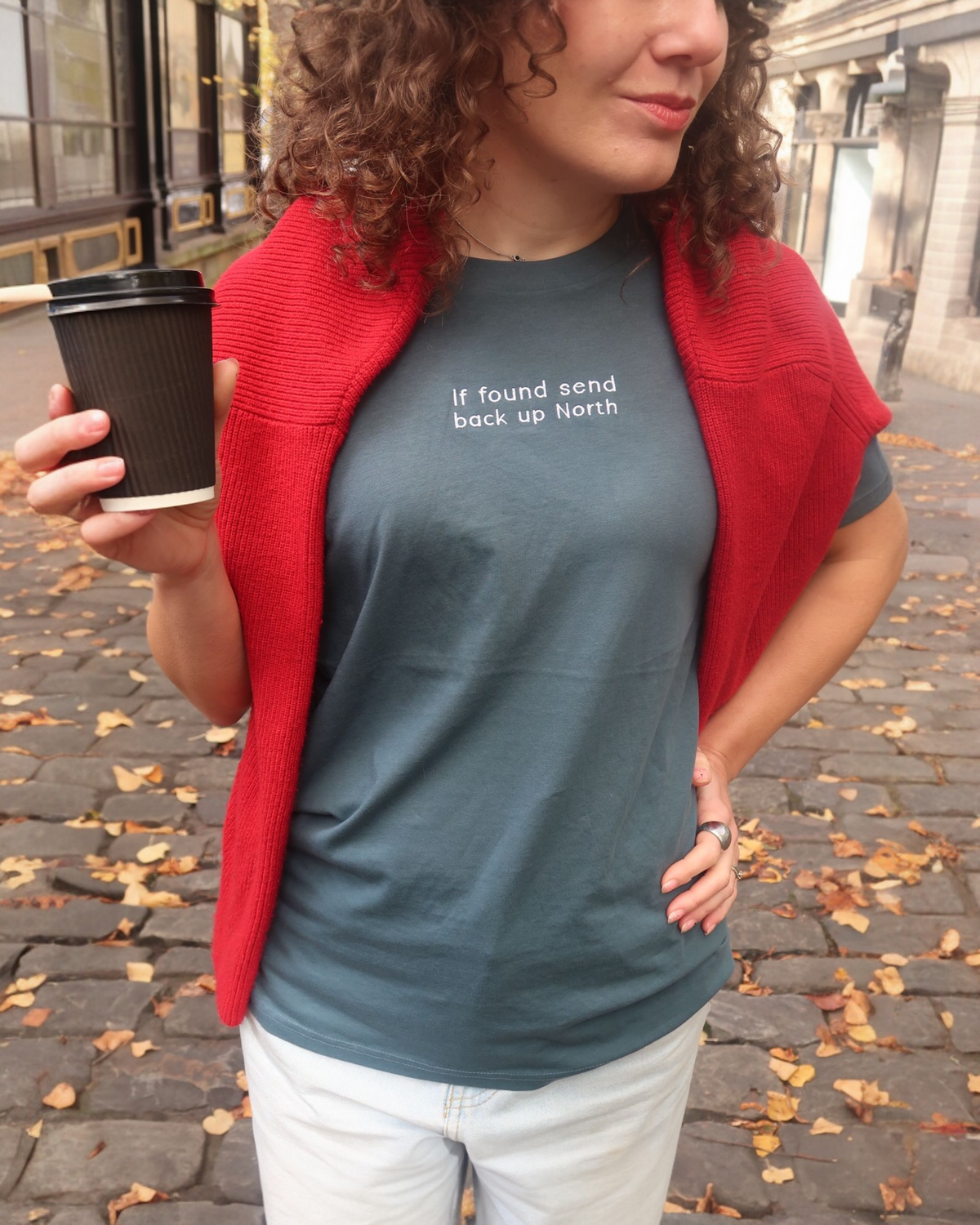 LighthouseLane unisex organic cotton t-shirt in slate blue with If Found Send Up North embroidery, worn by a woman.