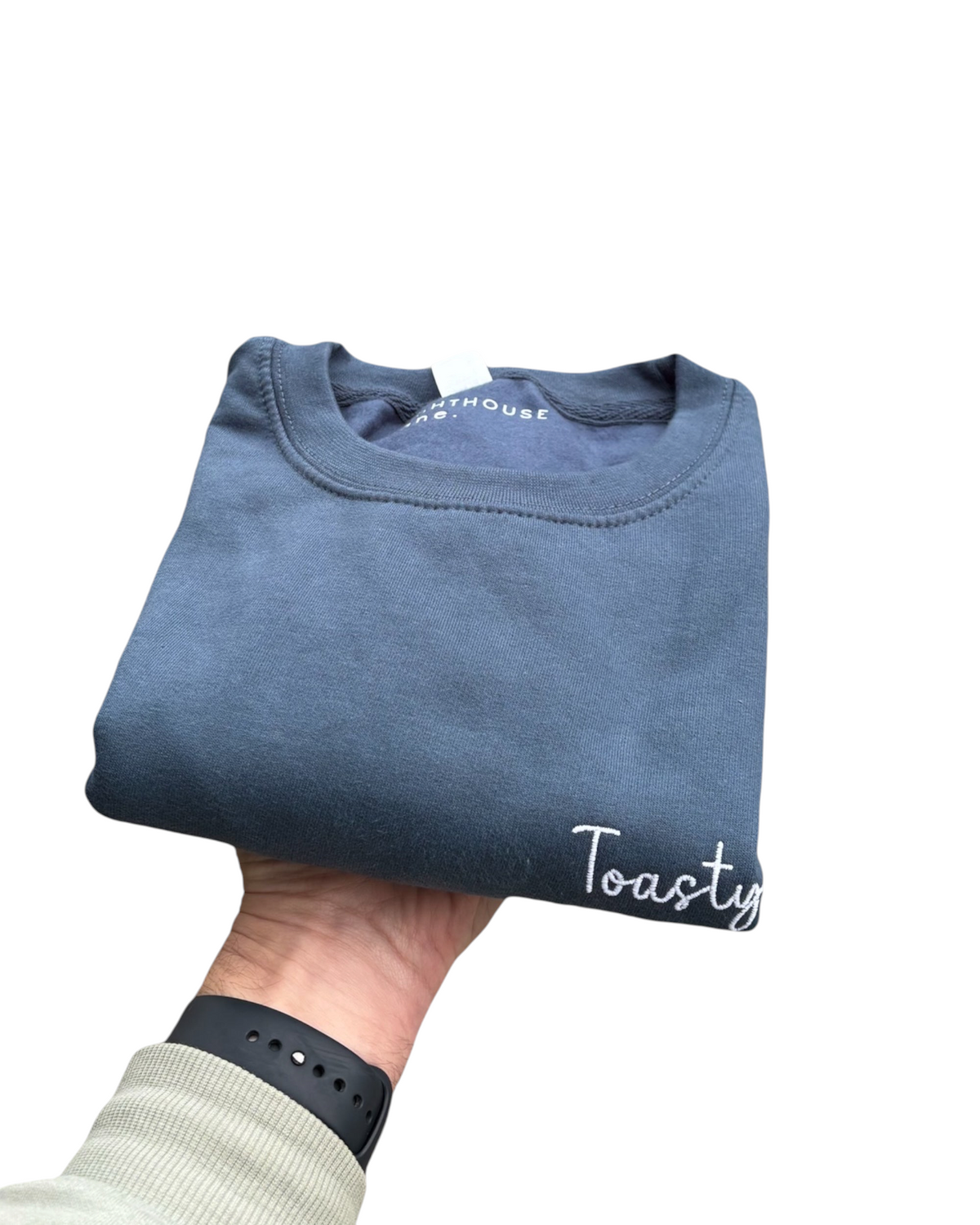 LighthouseLane Toasty embroidered navy blue cotton blend unisex sweatshirt folded and held in hand