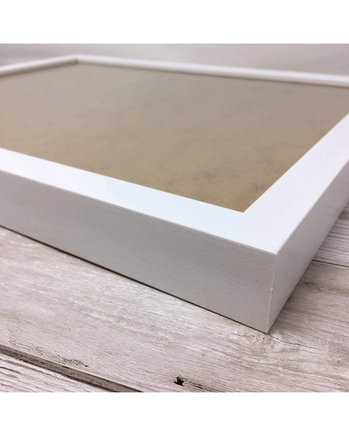LighthouseLane deep white handmade Polcore frame for art prints, shown from a side angle on a wooden surface.