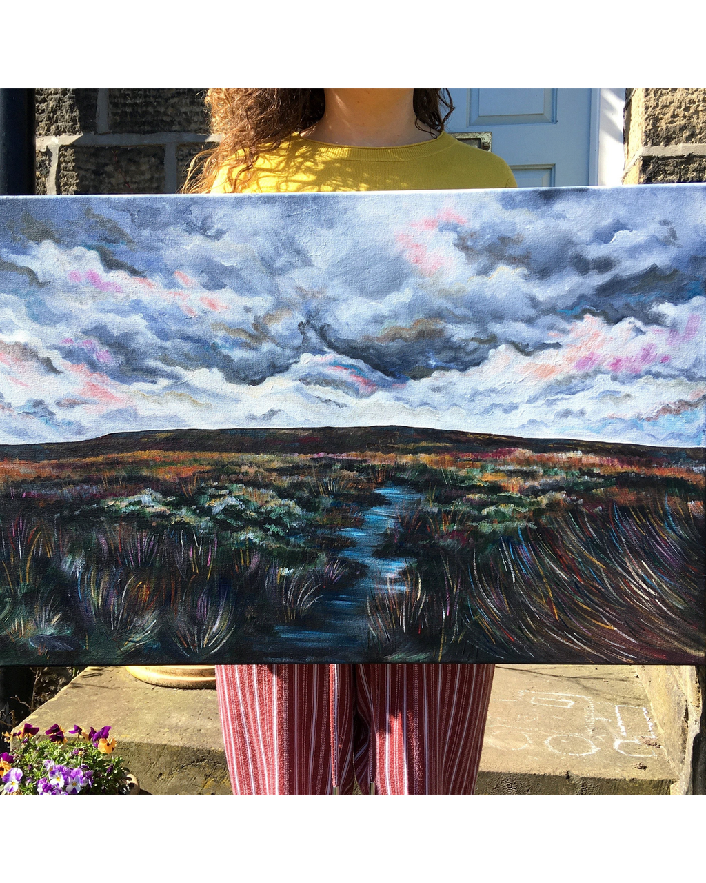 LighthouseLane Yorkshire moorland painting with a stormy sky, held by a person outdoors in natural light.